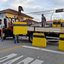 Imagem de avenida sendo fechada por caminhão com barricadas de cimento