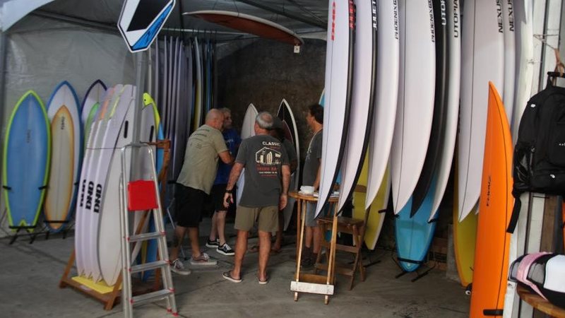 Homens e várias pranchas de surfe