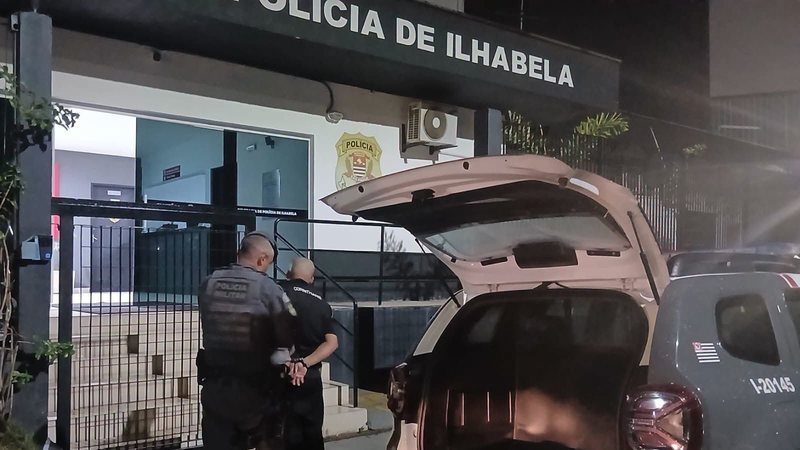 A imagem mostra a Delegacia de Polícia de Ilhabela, no litoral do estado de São Paulo, durante uma ocorrência policial com agentes fardados e uma viatura