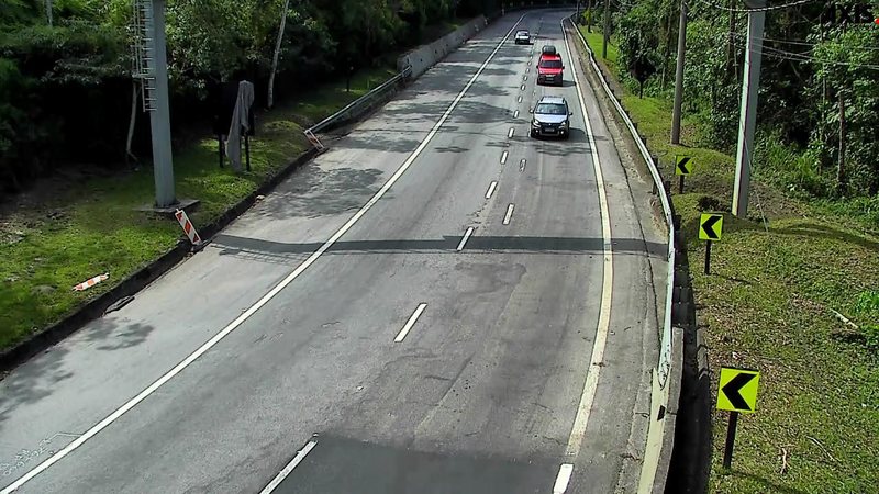 Trecho da rodovia dos Tamoios com veículos circulando em pista de duas faixas