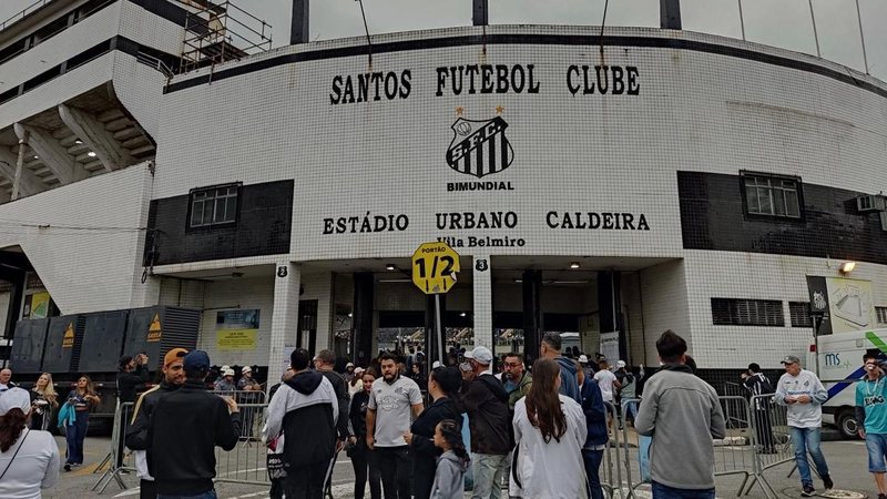 Imagem do estádio Urbano Caldeira, a Vila Belmiro, com torcedores na frente de um dos portões
