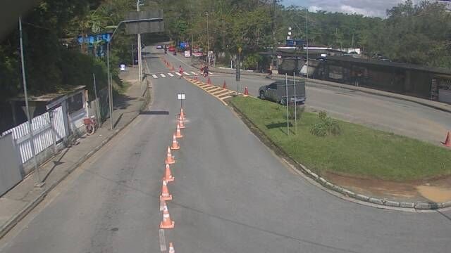 Área de espera para a travessia entre Bertioga e Guarujá, com cones sinalizando as faixas de acesso e veículos aguardando