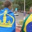 O velejador envolto pela bandeira de Ilhabela ao lado amigo envolto pela bandeira do Brasil