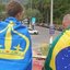 O velejador envolto pela bandeira de Ilhabela ao lado amigo envolto pela bandeira do Brasil