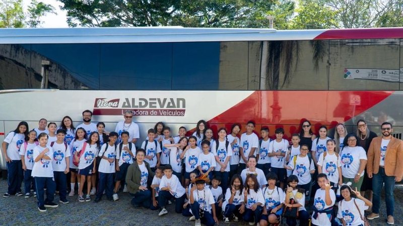 imagem dos estudantes na frente do ônibus que os transportou para o evento
