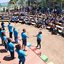 Imagem de diversas pessoas em cima de um palco e uma arquibancada também cheia