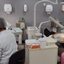 Imagem de duas dentistas sentadas, cada uma cuidando da boca de um paciente