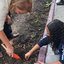 Uma criança e uma mulher plantando uma semente de àrvore