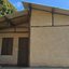 Imagem mostra uma pequena casa rústica construída com técnicas de bioconstrução, apresentando uma estrutura