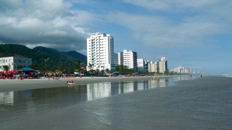 A imagem mostra a praia e a linha de edifícios de Mongaguá, situada no litoral sul do Estado de São Paulo, no Brasil