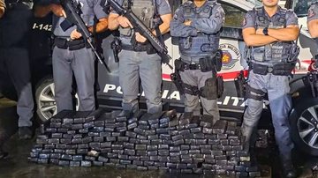 Foto de policiais com carga apreendida