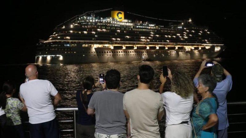 Pessoas vendo a passagem de um cruzeiro