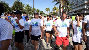 Imagem de pessoas camisas brancas, caminhando em calçada