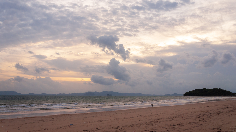 Praia com sol e muitas nuvens.