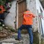 Agentes da Defesa Civil vistoriando casa no morro