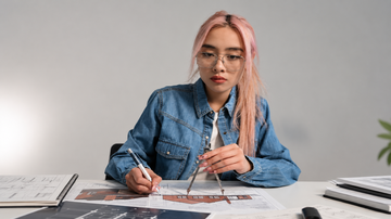 Mulher trabalha em um projeto de móveis sobre uma mesa
