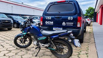 Imagem mostra motocicleta azul recuperada pela GCM diante de viatura municipal