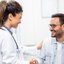 Médica de jaleco conversa com paciente