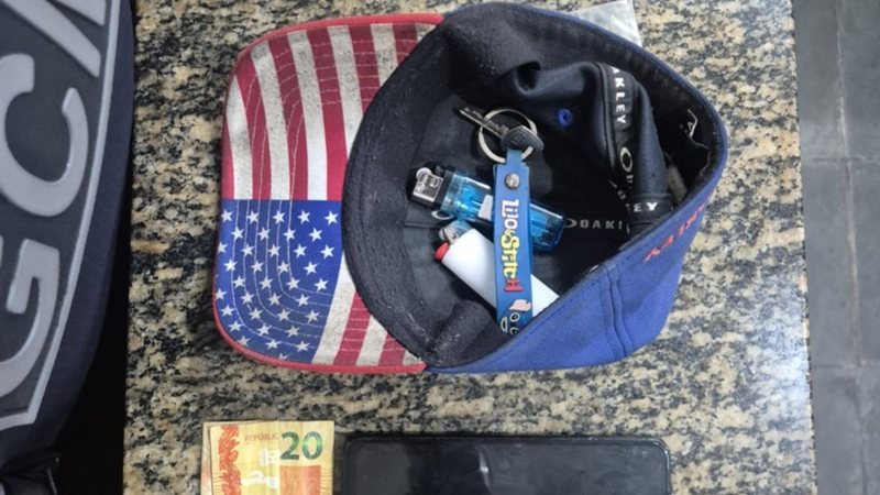 Imagem mostra apreeção de dinheiro, celular e outros objetos