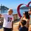 Homem apresenta ponto turístico de São Vicente para uma família