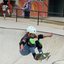 A imagem mostra a jovem skatista brasileira Scarlett Vilalva, mais conhecida como Cacá Vilalva, executando uma manobra em uma pista de skate