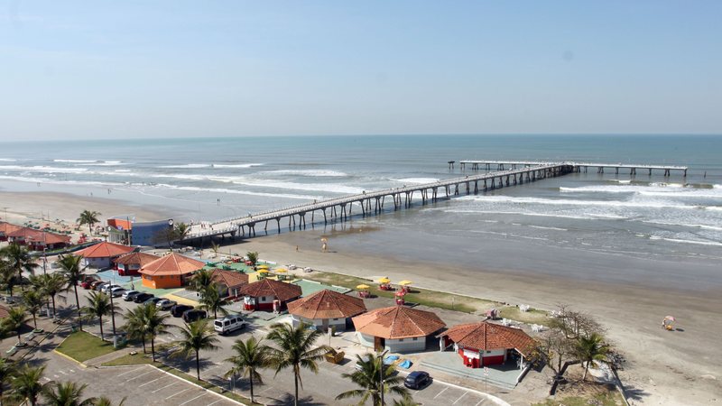 Imagem de praia com píer extenso