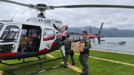 Imagem de equipe transportando as urnas em um helicóptero