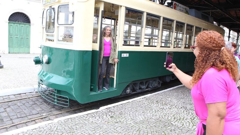 Mulher de rosa posando para uma foto no bonde