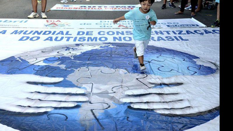 Dia Mundial de Conscientização do Autismo é celebrado em 2 de abril Governo lança cartilha para crianças com autismo Menino brincando em grande banner sobre Dia Mundial de Conscientização do Autismo - © Tania Rego/Agencia Brasil