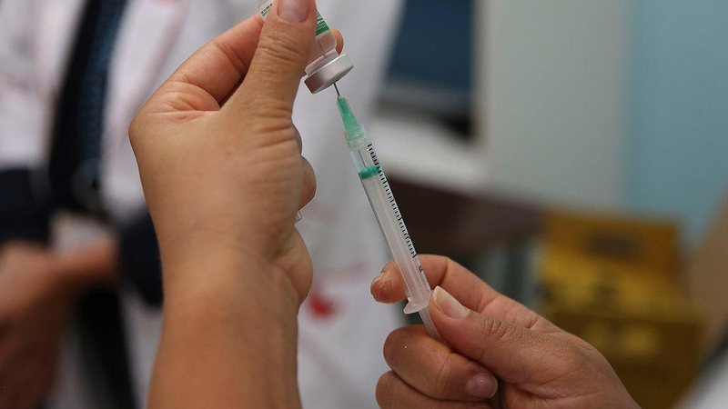 De acordo com a prefeitura, estarão disponíveis no sábado imunizantes contra poliomielite, covid-19, gripe, meningite e HPV, além das demais vacinas de rotina do calendário anual de vacinação Vacina Pessoa com uma vacina na mão - Marcello Casal Jr./Agência Brasil