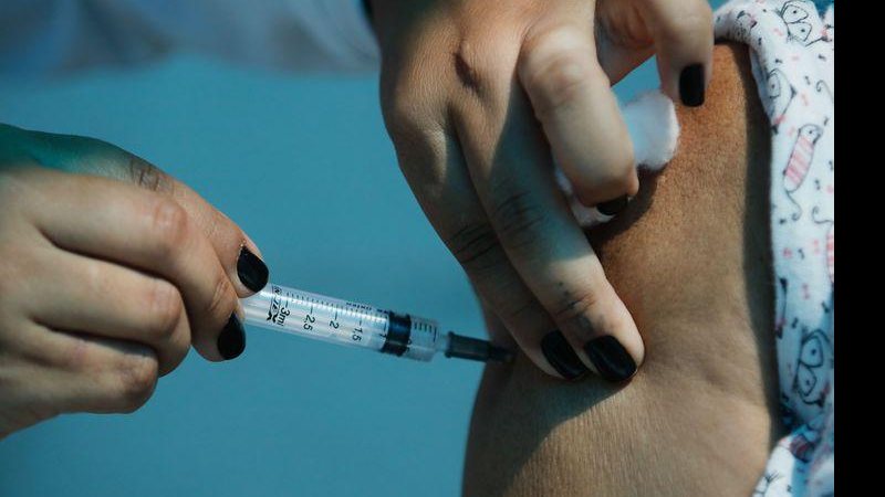 É importante ressaltar que vacinas de rotina que fazem parte do calendário nacional de imunização são oferecidas de acordo com a idade Vacina contra covid-19 Pessoa aplicando uma vacina no braço de outra - © Tânia Rêgo/Agência Brasil