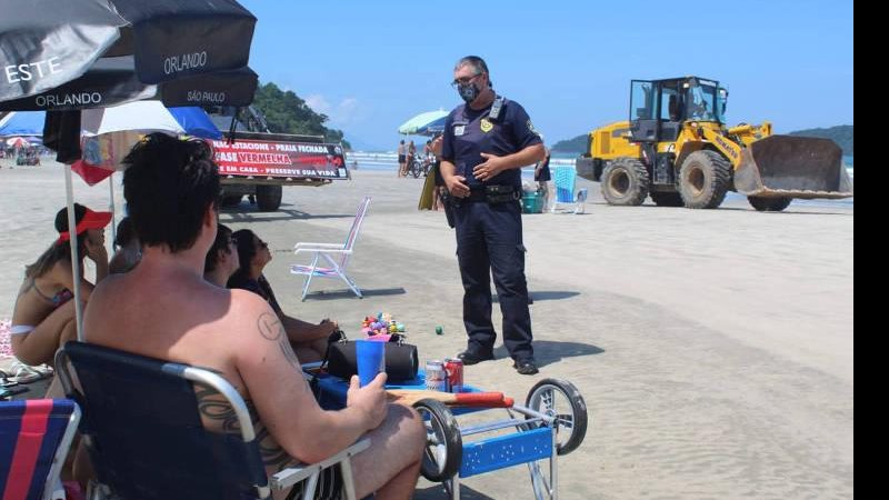 Turistas, sem máscaras, desobedecem proibição de permanência em Praia de São Sebastião; Prefeitura usou um trator para tentar dissuadir permanência de banhistas, mas não funcionou; medida foi criticada Trator em São Sebastião - Foto: Divulgação / PMSS
