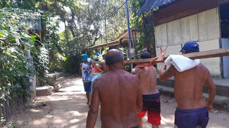 Moradores fazem revezamento para carregar doente pela trilha - Arquivo pessoal/Divulgação