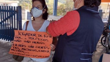 Moradora leva placa com homenagem a profissionais da saúde - Foto: Divulgação