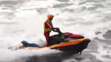 Resgate em busca do banhista desaparecido no mar Surfista tenta salvar banhista, mas não chega a tempo de resgatá-lo Homem do resgate em um jet ski - Reprodução