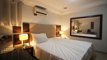 Imagem ilustrativa de um quarto de motel Homem surta dentro de motel, quebra lixeira do quarto e assusta clientes e funcionários do local Imagem do interior de um quarto de motel com cama, ar condicionado, espelho, iluminaria e abajur - Divulgação