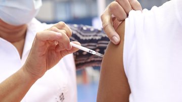 Guarujá é a única cidade da região a imunizar o segmento com a terceira dose Guarujá aplica terceira dose da vacina contra covid em profissionais da saúde Enfermeira aplicando vacina em um braço - Divulgação/Prefeitura de Guarujá