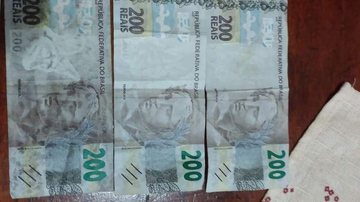 Comerciante levou prejuízo de R$ 600 em Santos Moradores da Baixada alertam para circulação de cédulas falsas de R$ 200 Três cédulas falsas de R$ 200 expostas sobre uma mesa - Divulgação/Facebook