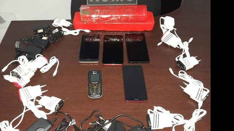 Criminoso carregava mochila com cinco celulares, dezenove carregadores e dois tabletes de maconha Homem é detido tentando jogar celulares e drogas para dentro de presídio em Mongaguá Celulares, carregadores e drogas aprendidas pela Guarda Municipal e expos - Divulgação/Romu