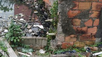 Limpeza em canais retira 2,5 toneladas de lixo em Santos Homem limpando um dos canais - Divulgação/Prefeitura de Santos