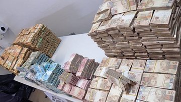 No local estavam escondidos diversos pacotes com notas de Real e Dólar americano Caminhoneiro é flagrado com mais de R$ 11 milhões em espécie - Foto: Divulgação Polícia Militar