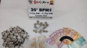 Drogas e dinheiro presos pelos policiais Dupla é presa por tráfico de drogas em São Sebastião (SP) drogas e dinheiro sobre um capô de uma viatura policial - Foto: Vigésimo BPMI