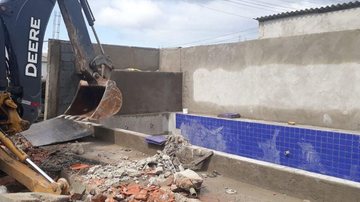 Duas casas foram demolidas Casa com piscina construída em área de preservação é descoberta e demolida em São Vicente Retroescavadeira demolindo uma das casas - Divulgação/Prefeitura de São Vicente