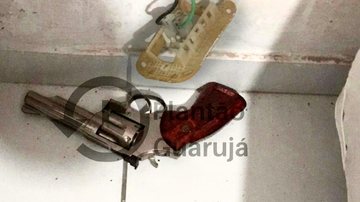 Mulher armada mata esposo agressor  Revolver no chão branco - Reprodução/Plantão Guarujá