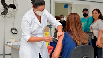 Vacinação contra covid-19 Vacinação contra covid em Ubatuba Enfermeira aplicando vacina em uma mulher - Divulgação/Prefeitura de Ubatuba