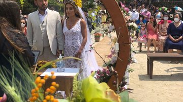 Primeiro casamento realizado na praia desde o início da pandemia teve cerca de 60 convidados Casamento na praia marca retomada de eventos no Guarujá Casal em frente ao altar, com os convidados sentados de máscara de fundo - Divulgação/Prefeitura de Guarujá