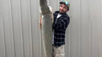 Pescador Danny Lee Smith diz ter ficado assustado com o tamanho do animal Peixe crocodilo com quase 18 kg e 1,37 metro de comprimento é pescado no Kansas Pescador com o peixe crocodilo nas mãos - Divulgação