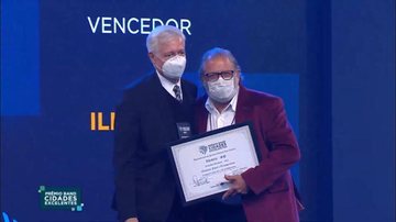 Prefeito de Ilhabela, Toninho Colucci, à direita na foto, recebe o prêmio durante evento do 'Band Cidades Excelentes' - Foto: Divulgação PMI