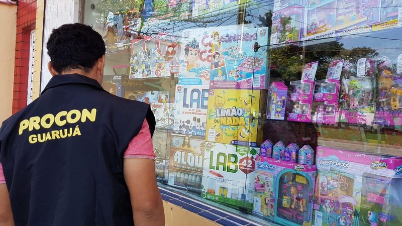 Procon realiza “Operação Dia das Crianças” no comércio de Guarujá Fiscal do Procon olhando para uma vitrine de brinquedo - Divulgação/Prefeitura de Guarujá