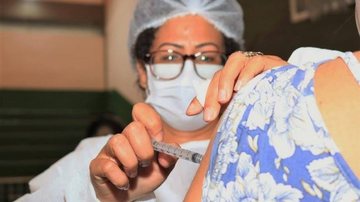 Postos estarão abertos das 8h às 16h Vacinação contra covid continua em Santos nesta segunda Enfermeira aplica vacina no braço de uma senhora - Divulgação/Prefeitura de Santos